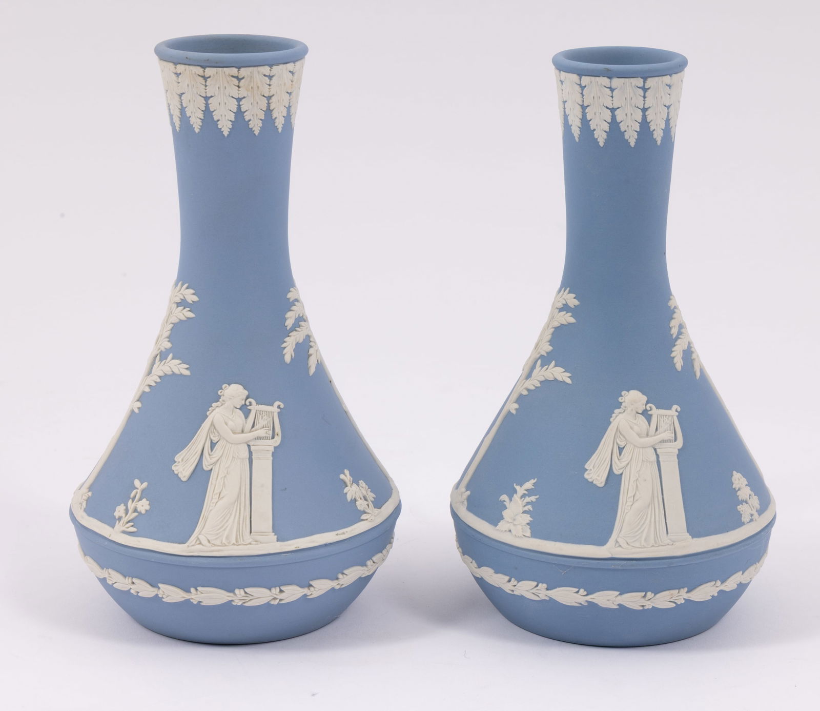 Pair of Wedgwood Jasperware Vases in Blue: A pair of Wedgwood Jasperware vases in blue and white decorated with a Greek motif. They are both marked on the underside with the Wedgwood maker's mark. They measure H 8 W 4 D 4 inches. Conditi