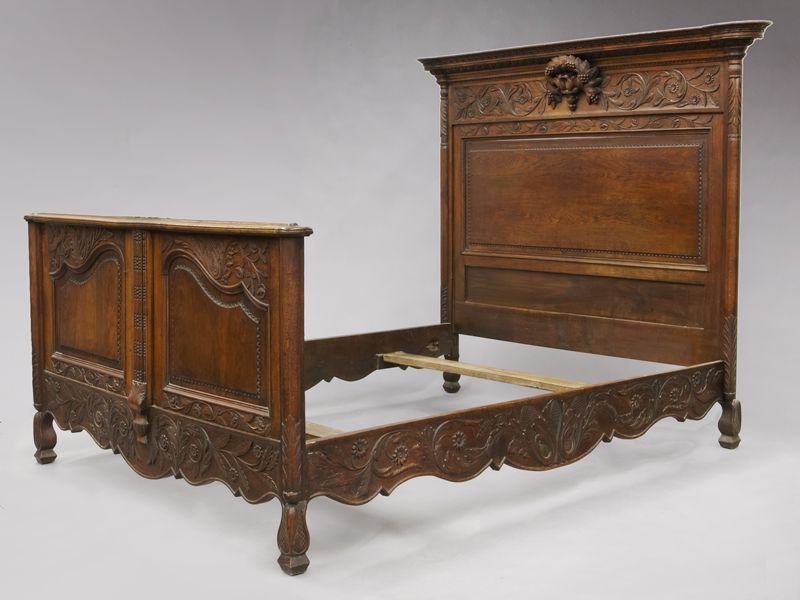 Country French carved oak bed: Country French carved oak bed with shaped, carved and molded cornice over a floral carved panel centered by carved doves, similarly carved footboard and highly carved scalloped rails. En suite with Lo