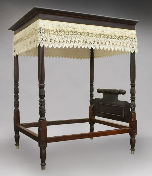 Classical American carved mahogany tester bed: Classical American carved mahogany tester bed with molded cornice, pineapple and foliate carved columns, paneled headboard with rolling pin crest and brass bound feet. 103"H x 74"W x 84"D, Circa - Ear