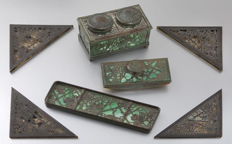 7 Pc. Tiffany Studios "Grapevine" pattern desk set: 7 Pc. Tiffany Studios "Grapevine" pattern desk set in green glass with gilt bronze mounts including: (1) pen tray stamped "1004"; (1) blotter stamped "995"; (1) double inkwell with original glass line