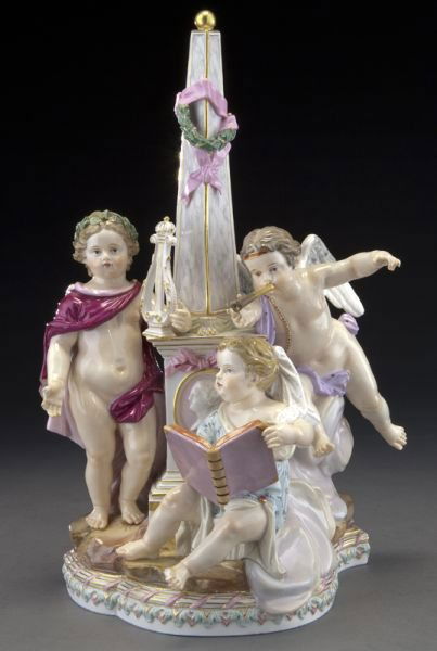 Meissen porcelain figural group allegorical of: Meissen porcelain figural group allegorical of music and writing, modeled as two putti playing instruments and one writing in a book, seated around an obelisk, on a rocky ground. Cross swords mark in