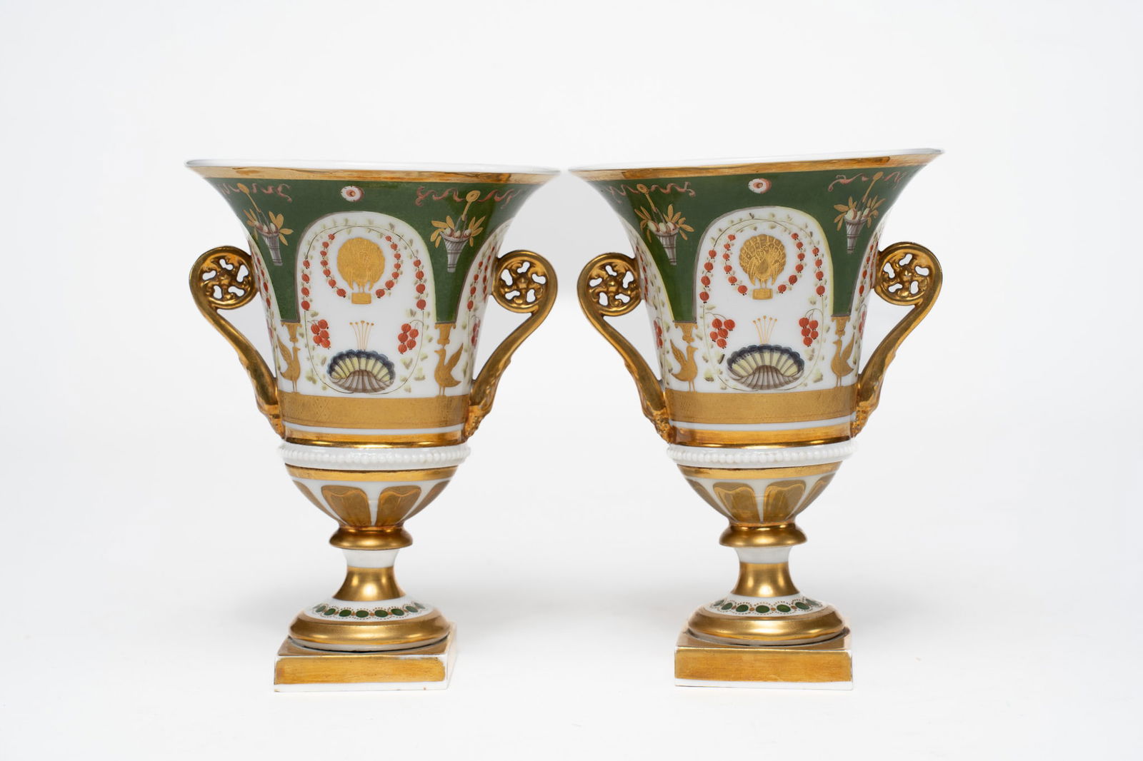 19th Century Pair of Continental Porcelain Painted Urns: A charming pair of 19th-century painted handled porcelain urns. Gilt and enamel decoration. Unsigned. Measuring: H 6.5 x W 5 x D 5 inches Condition: 1 urn has been repaired on lower part. Other shows