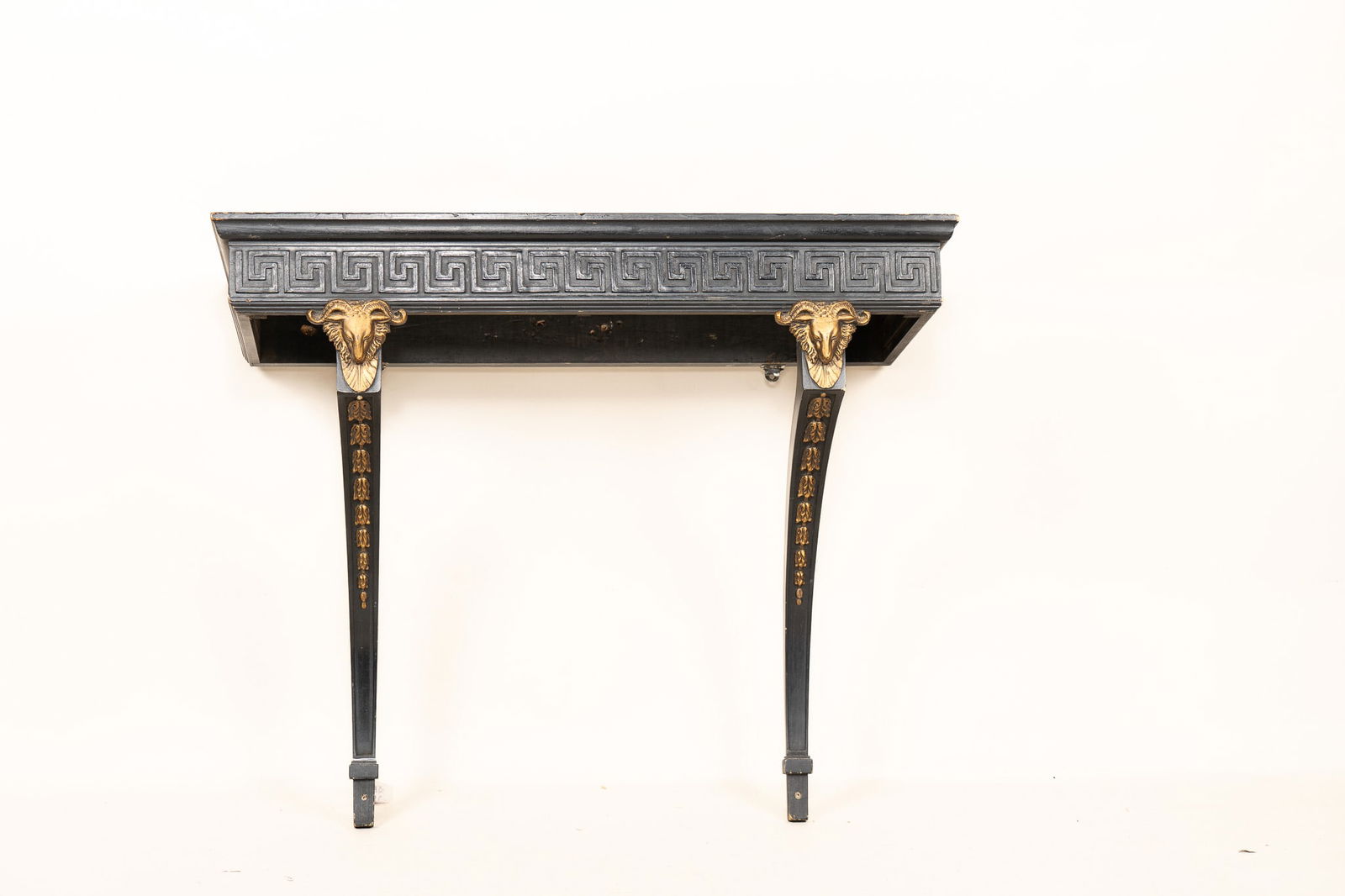 19th Century Empire Style Console Table: 19th Century Empire Style Console Table. Also known as a pier table, this piece is ebonized and features gilt ram's head accents and marquetry on the legs. The border on the top section is a Greek key
