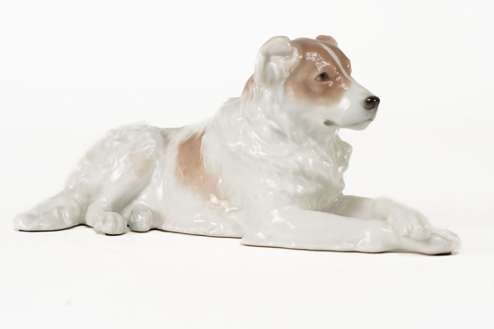 Antique 20th Century KPM Porcelain Dog: An early 20th Century dog by Berlin porcelain company, KPM. Signed on the underside with the blue sceptor mark along with KPM and 140 602 Dimensions: H 4 x W 9 x D 3 inches Condition: No signs of chip