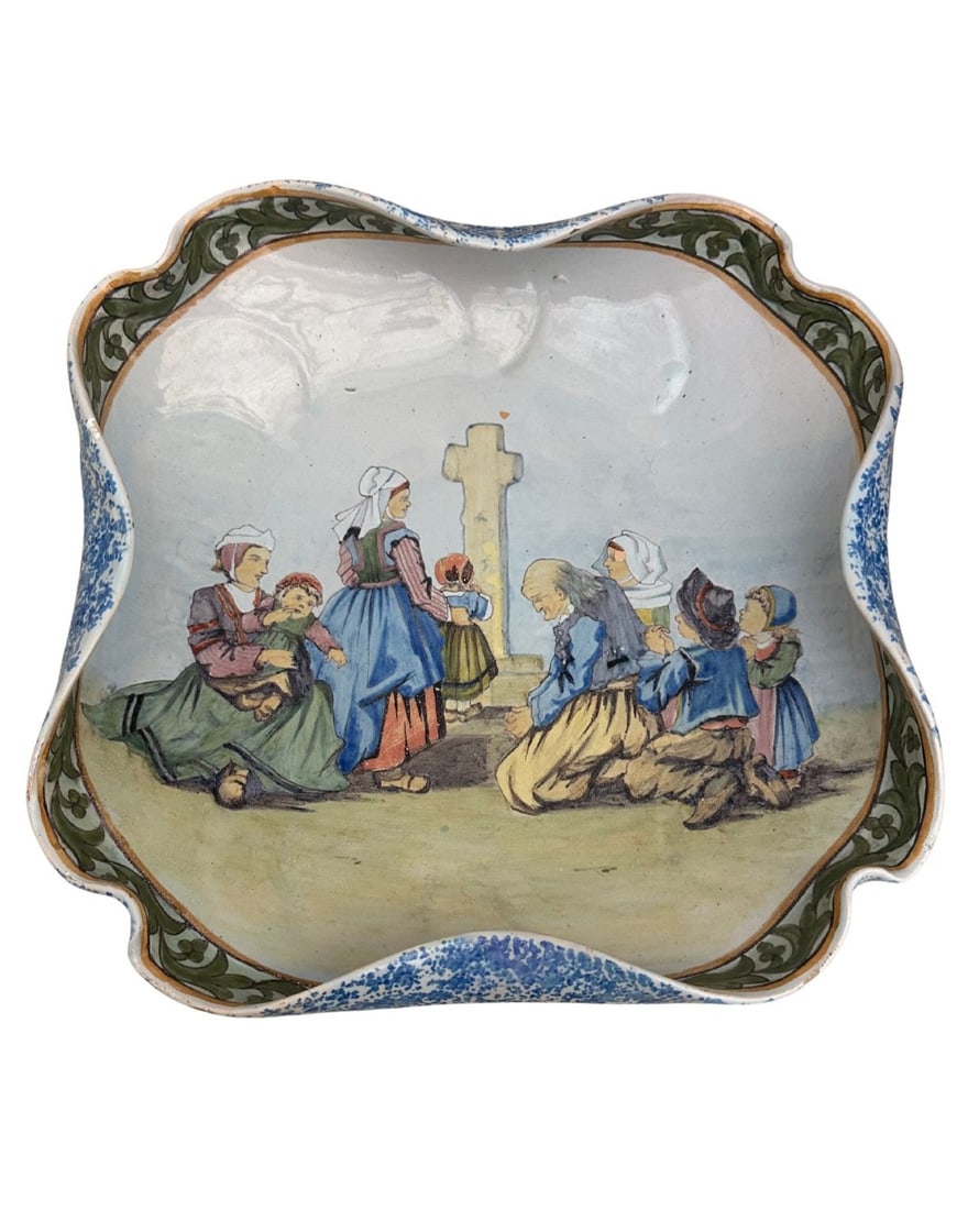 French Faience Porquier Beau Quimper Decorative Dish: French Faience Porquier Beau Quimper Decorative Dish. Dish with curved edges which depicts a group of people visiting a grave. Edge of dish is decorated with green leaves and the underside is speckled