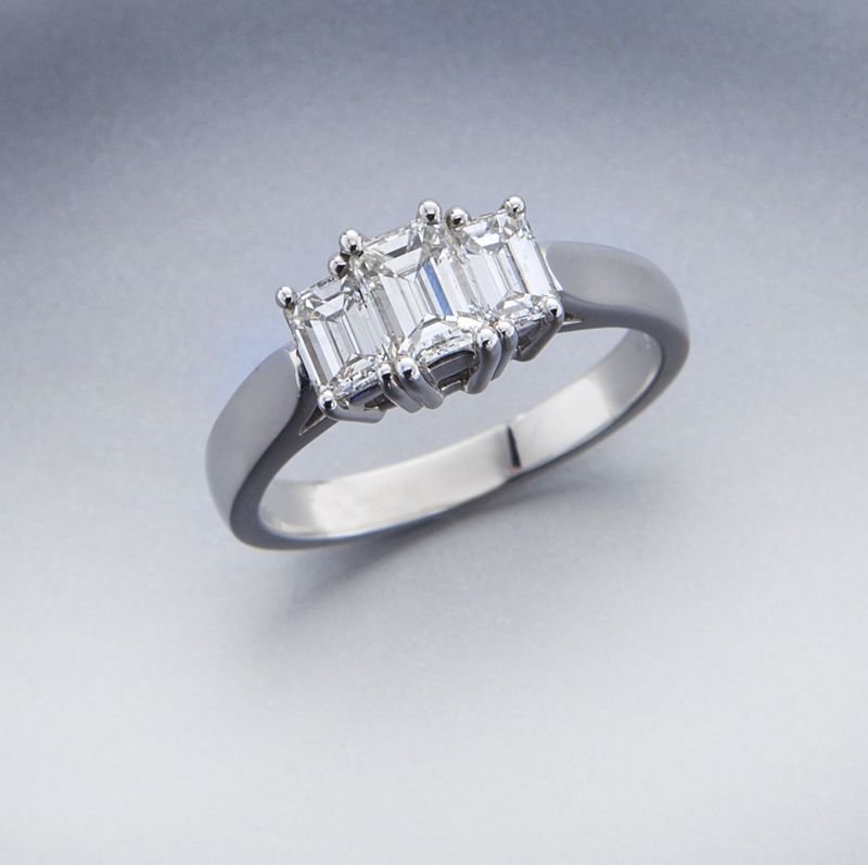 Kwiat platinum and three stone diamond ring: Kwiat platinum and three stone diamond ring featuring a central emerald cut diamond, .46 cts. approximate, G color, VS1 clarity, flanked by a pair of emerald cut diamonds, .40 cts. approximate total, 