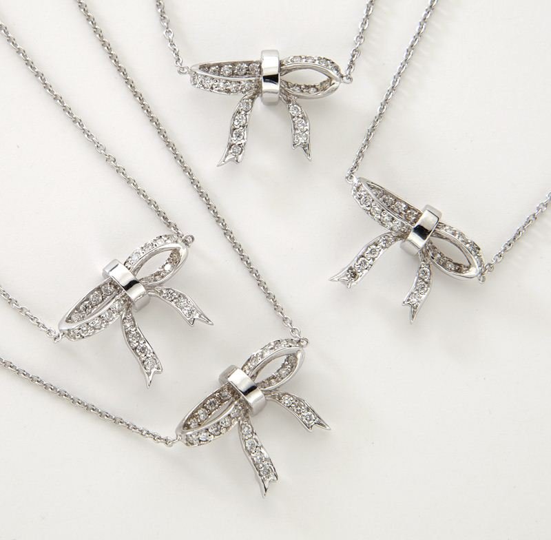 (4) Roberto Coin 18K and diamond "Bow" necklaces,: (4) Roberto Coin 18K and diamond "Bow" necklaces, each mounted with 25 round brilliant cut diamonds, .11 cts. approximate total each, G- H color, VS2-SI1 clarity, mounted in 18K white gold and on an 1