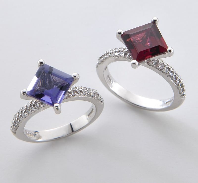 (2) Barry Kronen diamond and gemstone rings: (2) Barry Kronen diamond and gemstone rings each mounted with 38 round brilliant cut diamonds in 18K white gold, including (1) iolite and (1) garnet. Stamped, "Kronen 18K." Each 5.0 grams. Provenance: