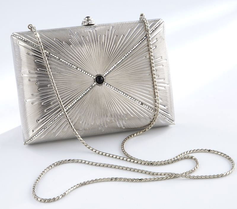 Judith Leiber silvered metal clutch: Judith Leiber silvered metal clutch with crystal sunburst design to the front, centered by a black onyx cabochon, metal shoulder strap, original mirror, change purse, and comb concealed within silver