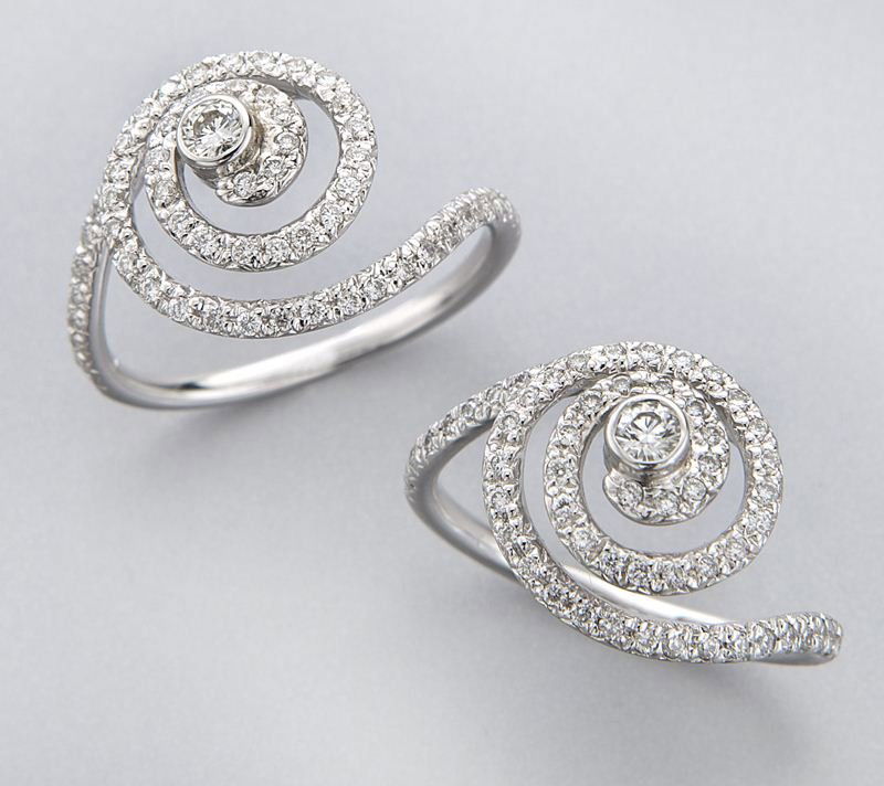 (2) Penny Preville 18K gold, diamond swirl rings,: (2) Penny Preville 18K gold, diamond swirl rings, each with 76 round brilliant cut diamonds mounted in 18K white gold. Stamped, "18K PP." 3.5 grams approximate each. Provenance: The estate of a gentle