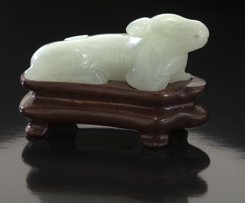 Chinese Qing carved white jade dog: Chinese Qing carved white jade dog raised on a rosewood stand. 2.5"L, Circa - 18th - 19th C.