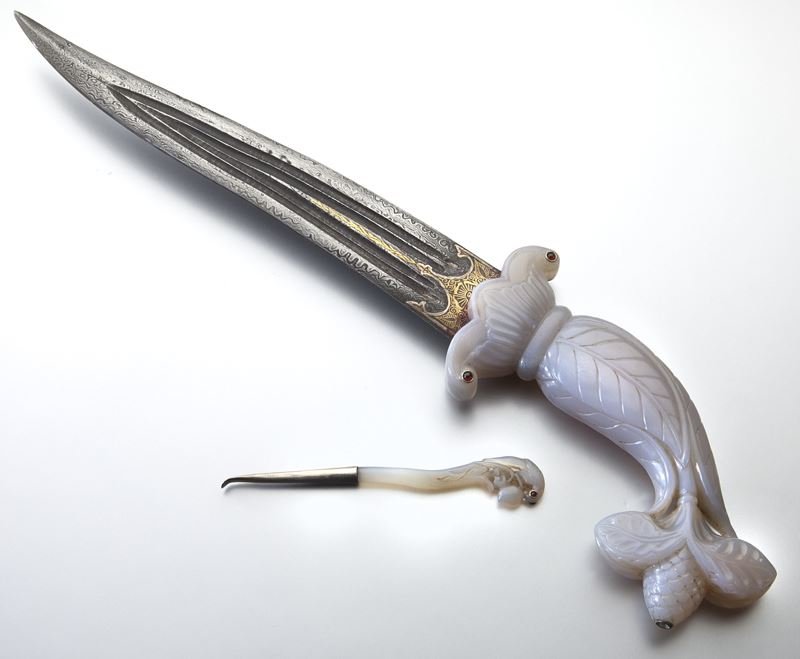 2 Pcs. Mughal style jade incl:: 2 Pcs. Mughal style jade incl: (1) jade handled dagger with foliate motif, 6"L, with a Damascus blade having gilt decoration at the hilt, 9.5"L; and (1) metal scoop with jade handle depicting a parrot