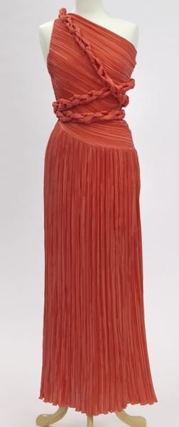 Mary McFadden pleated coral evening gown: Mary McFadden pleated coral evening gown with one shoulder, braided wrap around belt can be styled in various ways. Tag marked for Mary McFadden, size 4, measuring 57" L. Note: In the 60 collections t