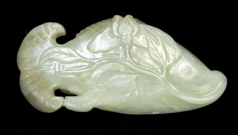 Rare Chinese Qing carved jade belt hook: Rare Chinese Qing carved jade belt hook shaped as a fish on a lotus leaf, the reverse with two round knobs, carved in low relief with exquisite details. Provenance: From the collection of a prominent