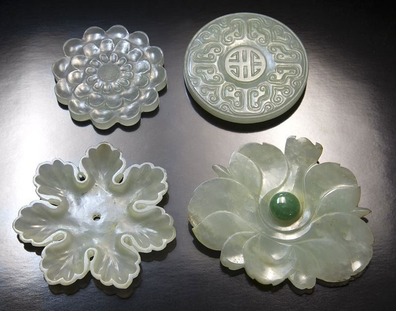 (4) Chinese Qing carved jade/jadeite costume: (4) Chinese Qing carved jade/jadeite costume ornaments, carved as multi-petal flower heads and pierced with double perforation, where thread could be strung to attach to the costume. Provenance: From