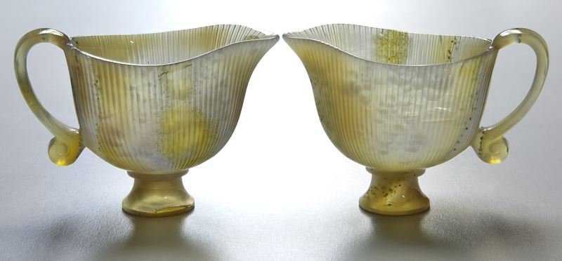 (2) Chinese Qing Mughal carved agate cups,: (2) Chinese Qing Mughal carved agate cups, shaped as a flower buds raised on a stepped pedestal foot, with a looped handle completed in an S curve and an everted spout, the thin walls further accented