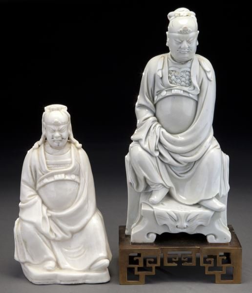 (2) Chinese Qing blanc de Chine porcelain figures,: (2) Chinese Qing blanc de Chine porcelain figures, both depict the God of war Guan Yu sitting on a chair in a majestic posture, with full attire including his official hat and belt. The first one in s
