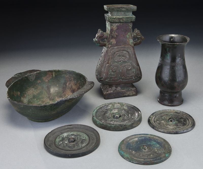 (7) Chinese archaistic bronzes.: (7) Chinese archaistic bronzes. (4) small Han - Tang style circular mirrors, (1) large Han ear-cup, (1) small ancient zun, (1) small Zhou style lidded rectangular vase fanghu. Tallest 7.75"H. Provenan