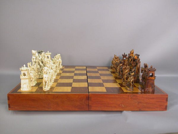 Large Chinese carved ivory chess set: Large Chinese carved ivory chess set with 32 carved ivory playing pieces, and large wooden case that folds out to become the board. The interior of the box is lined and fitted for the pieces. All of t