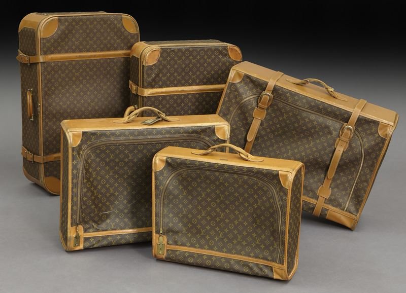 Set of (5) Louis Vuitton monogram suitcases: Set of (5) Louis Vuitton monogram suitcases with leather straps and brass buckles. 23.75" H x 36" L x 11.25" W (largest), Circa - 20th C.