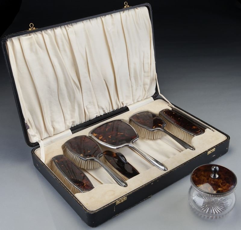 7 Pc. sterling and faux tortoise dresser set: 7 Pc. sterling and faux tortoise dresser set including (4) brushes, (1) hand mirror, (1) nail buffer, (1) glass bodied cosmetic jar, each mounted in sterling silver with faux tortoise shell panel deco