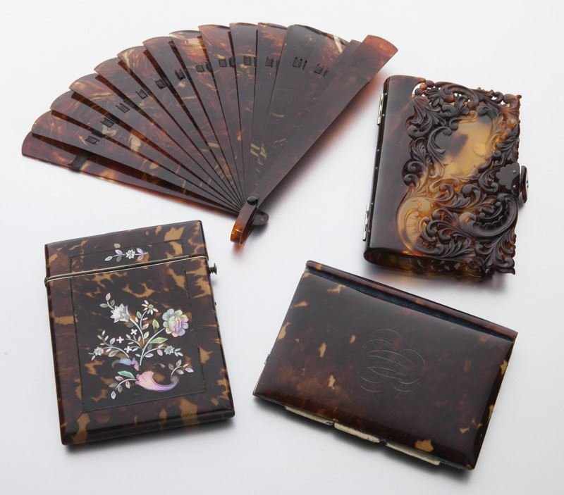 4 Pcs. Faux tortoise shell group: 4 Pcs. Faux tortoise shell group comprised of: (1) fan; (1) cigarette case with floral shell inlay; (1) pocket book monogrammed to front with "M"; (1) pocket book with foliate pierce carving. Dimensio