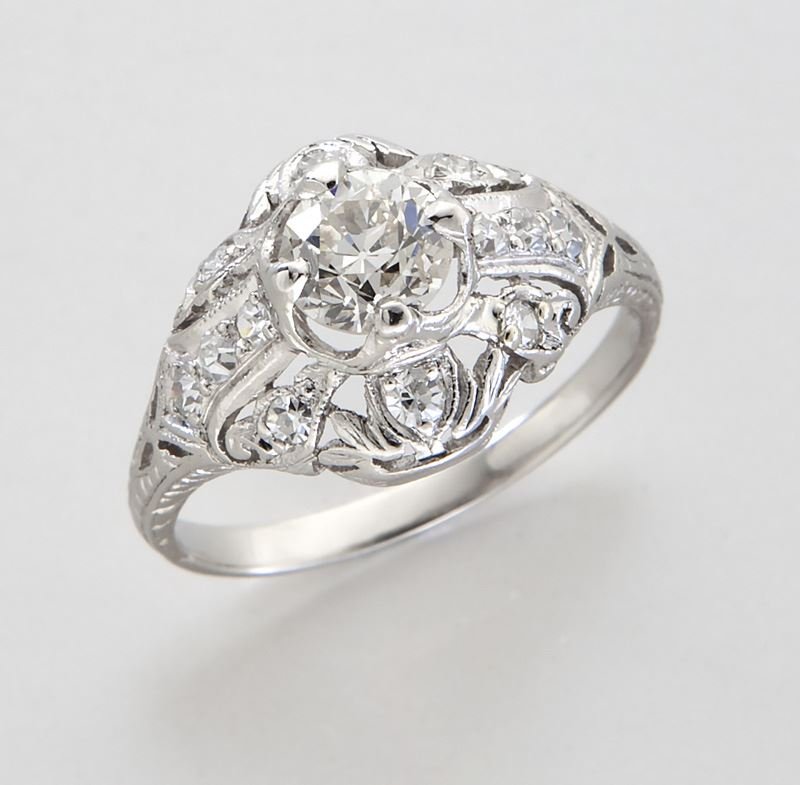 Edwardian platinum and diamond ring: Edwardian platinum and diamond ring featuring a central old European cut diamond, .80 cts. approximate, accented by 12 old European cut diamonds in a pierced platinum (tested) mounting. 3.5 grams. Siz