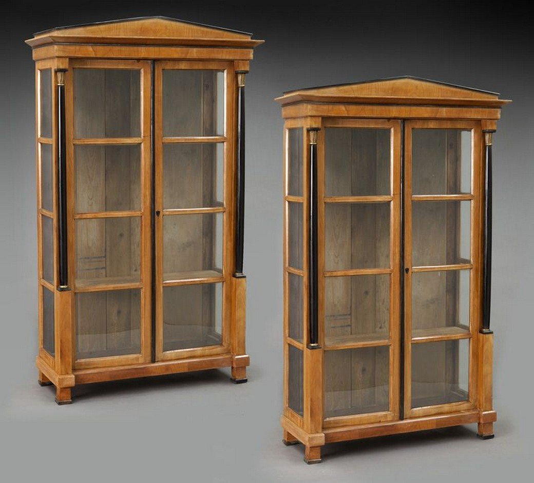 Pr. Beidermeier style bookcases,: Pr. Beidermeier style bookcases, the molded pediment over two glass panel doors flanked by lacquered Egyptian terms, interior with wooden shelves, raised on block plinth and square feet, with key. 76.