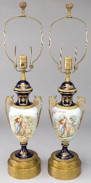 Pr. Sevres style porcelain lamp bases w/ ormolu: mounts, adjustable harps and cobalt blue elements. Each vase is signed by a different artist. Top of one with professional restoration. 29"H x 6"Dia. base, Circa - First half of the 20th.