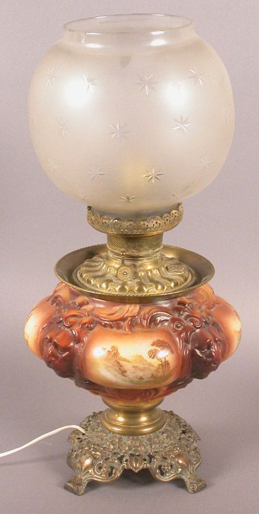 Victorian style Gone With the Wind lamp with: lion masks and painted desert scenes of camels, palm trees and people. Ornate brass base. 21.75" tall, circa early 20th century.