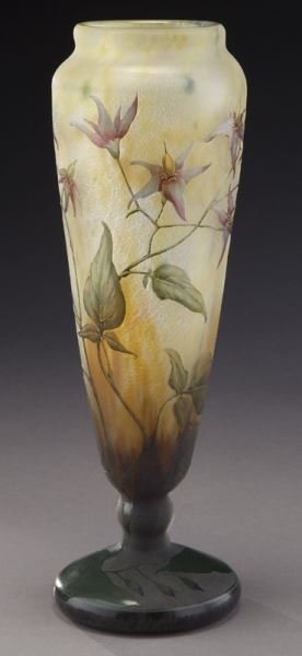 Daum Nancy French cameo glass vase,: Daum Nancy French cameo glass vase, of footed cylindrical form with a purple foot extending to a mottled orange body graduating to a yellow rim decorated with purple flowers and buds on random green l