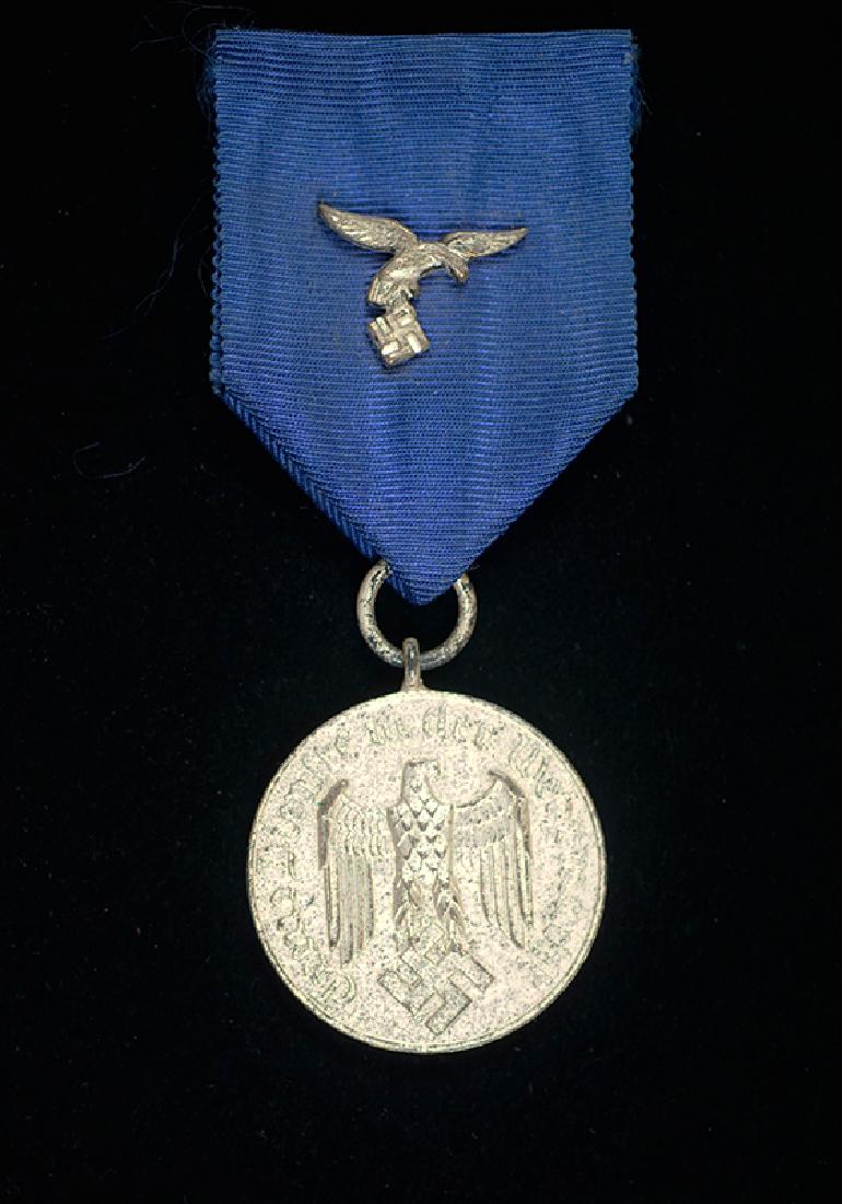 WWII Luftwaffe 4 Year Service Medal: Wehrmacht 4 Year Luftwaffe Long Service Medal; silvered medal on its original ribbon having early silvered (droop-tail) Luftwaffe Eagle device; excellent condition.