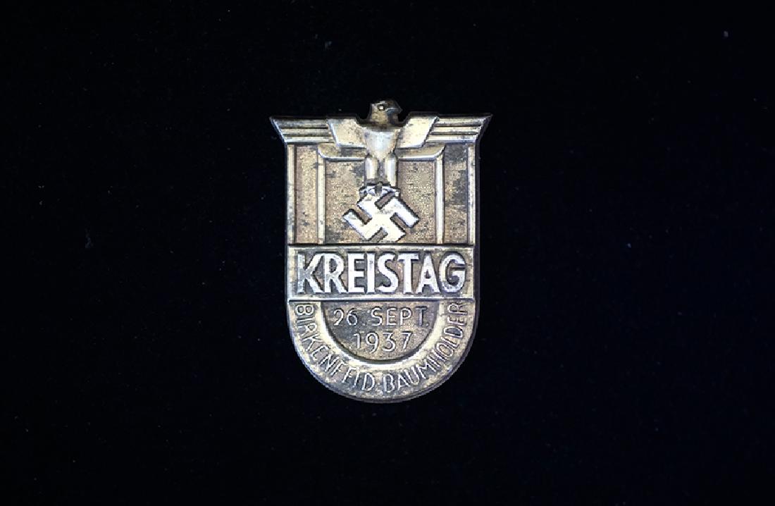 German 1937 Kreistag-Baumholder Badge: German 3rd Reich tinnie dated 1937; 40mm bronzed steel-alloy with pin-back; very good condition.