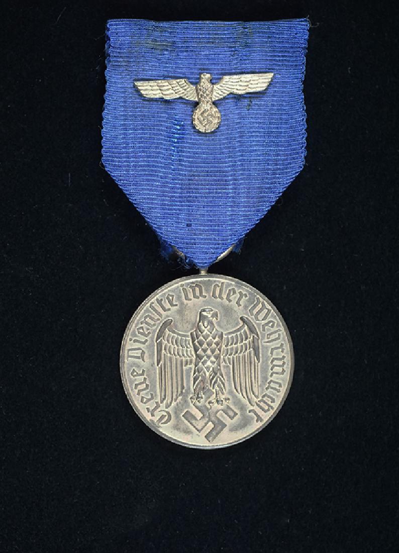 WWII Wehrmacht 12 Year Service Medal: Wehrmacht 12 Year Army or KM Long Service Medal; silvered medal on its original ribbon having Wehrmacht Eagle device; excellent condition.