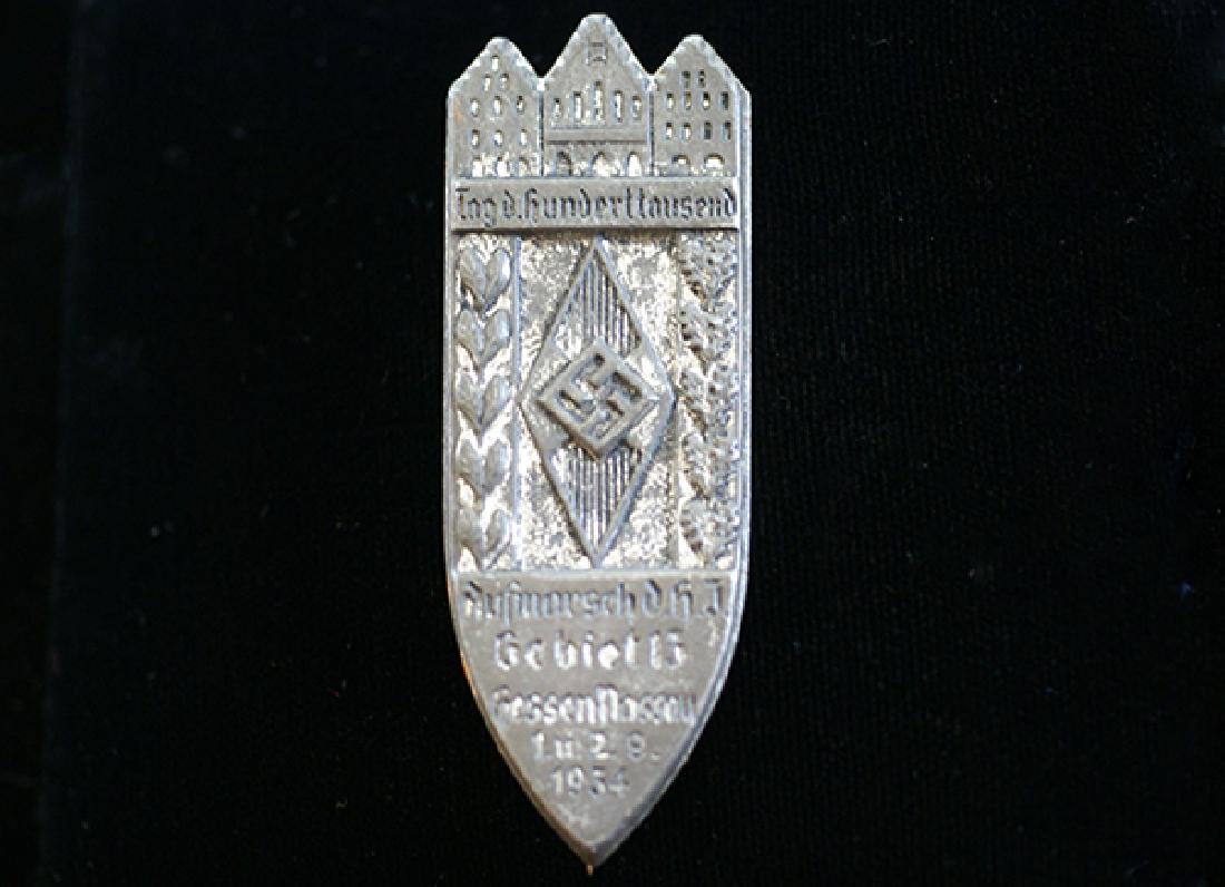 German 1934 HJ Hessen-Nassau Badge: German 3rd Reich HJ tinnie dated 1934; 57mm stamped steel with straight-pin; very good condition.