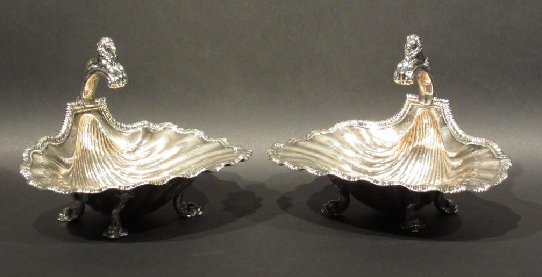 Pair Sterling Silver Shell Form Bowls: Shell form with gadroon rims, Lion handles leading to a dolphin back post and 4 dolphin legs each. Unusual and faded mark. 8"w X 7"d X 5.5"h. 30 oz troy. (From a Central Park West Estate)