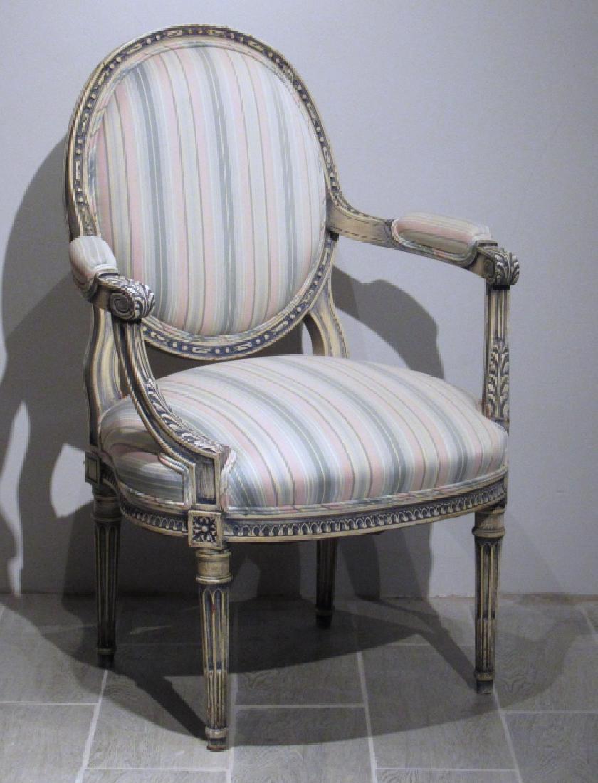 French Louis XVI Style Fauteuil: Painted and carved, sloping arms with stop fluted legs. Over upholstered back arms and seat. 25"w X 21"d X 36"h. (From a Central Park West Estate)
