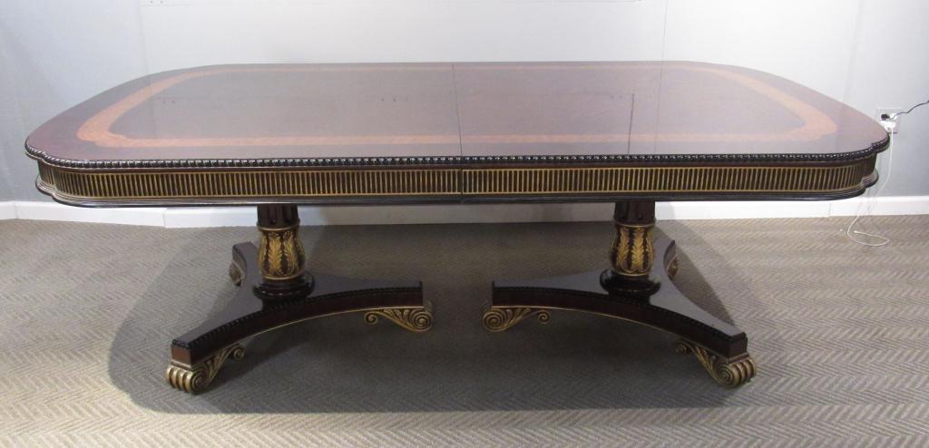 EJ Victor Neo Classical Double Pedestal Dining Table: Mahogany table with cross banded curled corners, gilt fluted apron on double pedestal bases. Single fluted and gilt carved posts with 3 scroll feet each, can be mounted to point in or out. 1 aproned l