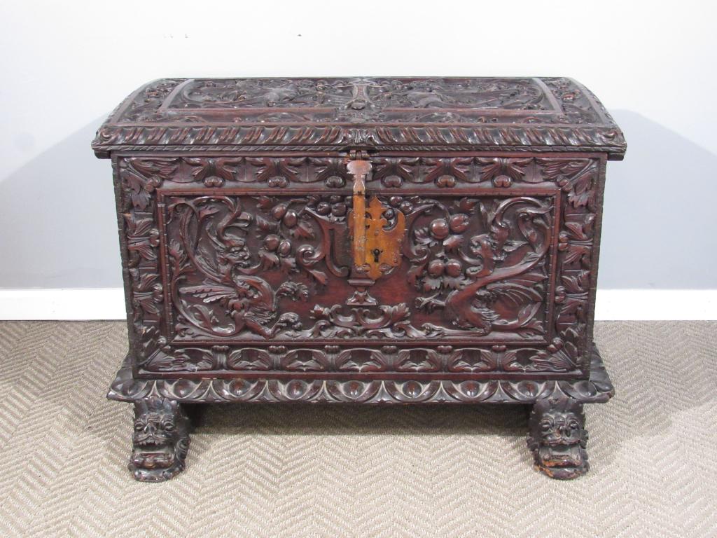 English Oak Blanket Chest: Heavily carved with griffin figural top and front. Lion carved feet with gadroon trim. Large heavy metal mounts with original key. 42"W X 28"D X 28"H