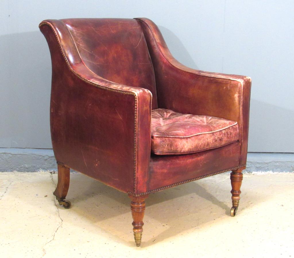 George Smith Style Vintage Club Chair: Distressed leather squared frame, with turned front legs and sloping back legs, all on castors. 27" X 31"D X 36"h