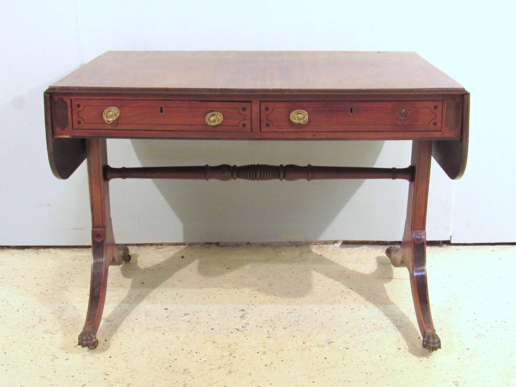 Antique Regency Style Sofa Table: Mahogany with classic drop sides, inlaid drawer fronts on a double splay leg base. Finished back. Needs refinishing. Metal paw feet on castors. 38" X 27" X 27"h
