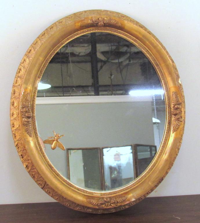 Antique American Oval Mirror: Gilt gesso mirror with interesting Gilt Metal 2" insect mount. 22" X 19" X 4" (A North Salem, NY Estate)