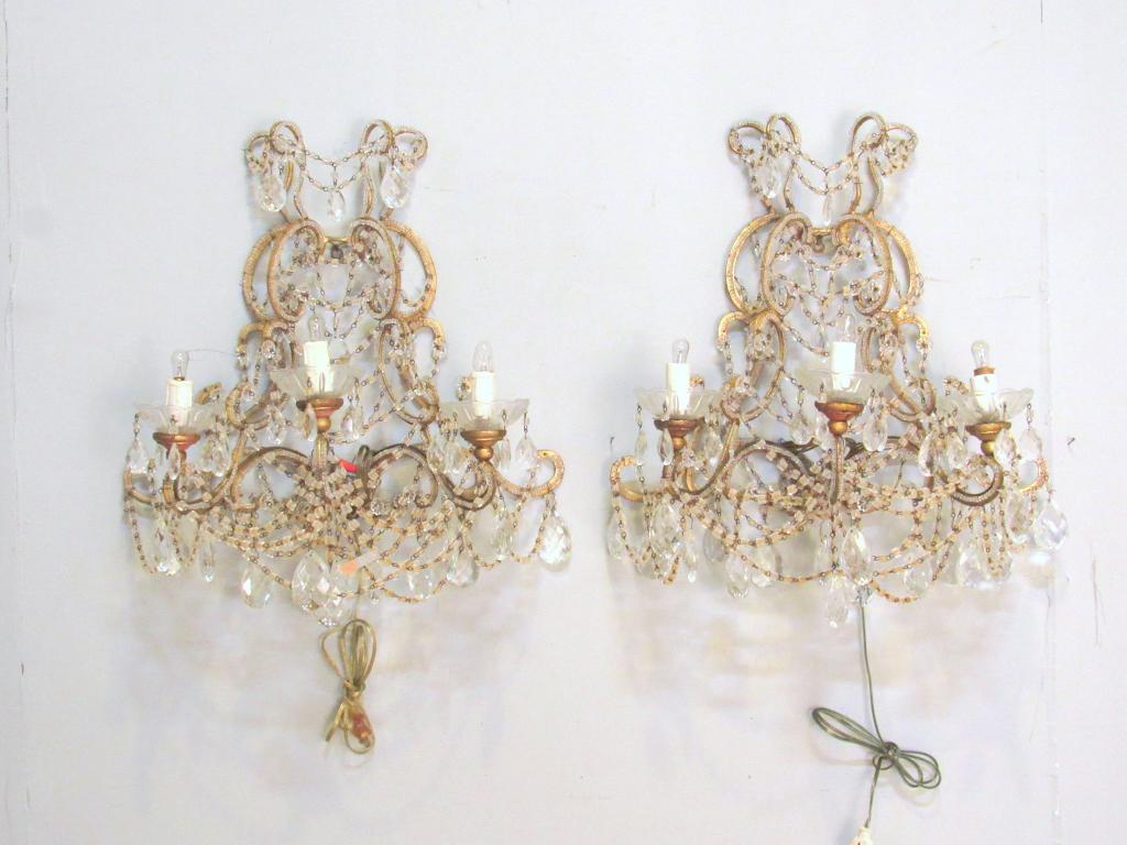 Pair Hollywood Regency Style Sconces: Gilt metal with beaded trim and crystal prisms, 3 arms with glass bobeches. 21" X 12" X 24"h (From a Watertown CT Estate)