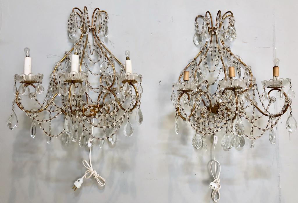 Pair Hollywood Regency Style Sconces: Gilt metal with beaded trim and crystal prisms, 3 arms with glass bobeches. 21" X 12" X 24"h (From a Watertown CT Estate)