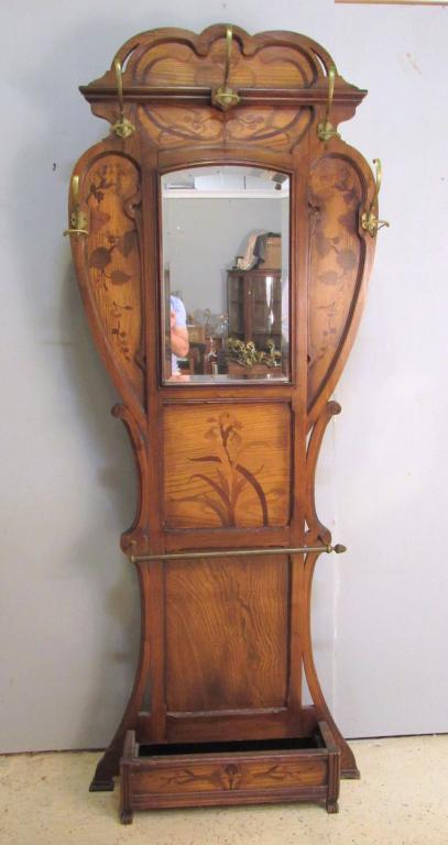 Art Nouveau Tall Hall Rack After Galle: All over inlaid oak with brass mounts, tin umbrella stand liner, beveled mirror back. 34" X 8.5" X 87" (A Tarrytown NY Estate)