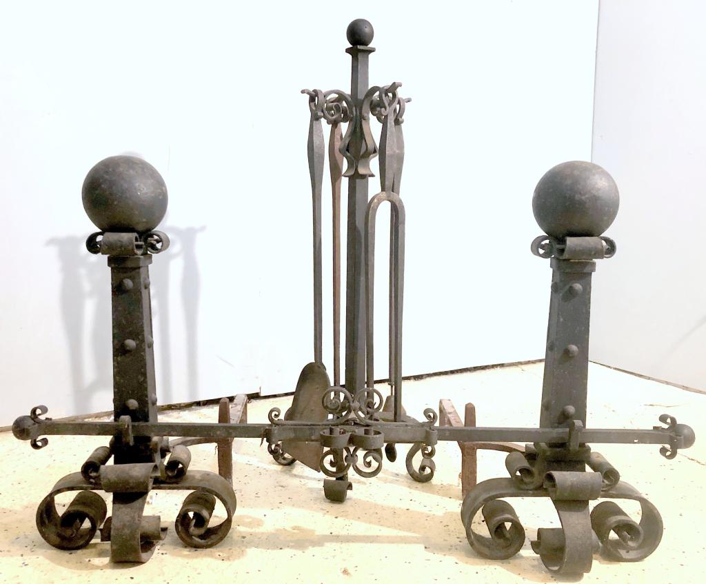 English Gothic Style Fireplace Set: Heavy ebonized iron. Pair cast and wrought iron andirons with center adjoining rod, together with tools on stand. Andirons 13" X 25" X 26"h