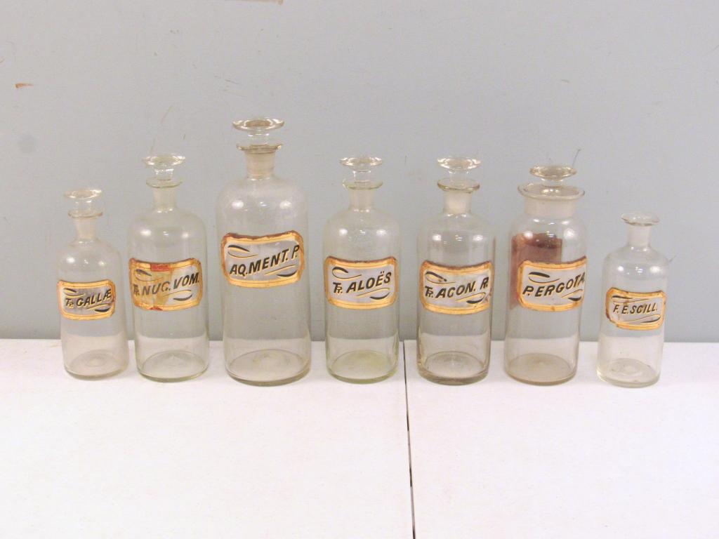 7 Vintage Glass Apothecary Bottles: 6 with stoppers. Not in perfect condition. Tallest 10" (A Tarrytown NY Estate)
