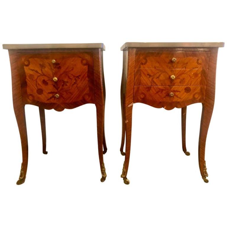 Pair French Louis XV Style Stands (102-6212): 1920s. One with 3 drawers, the other with a drop front door, and each having floral inlays supporting bronze galleried marble tops on casters. 26.5" x 16.75" x 13"