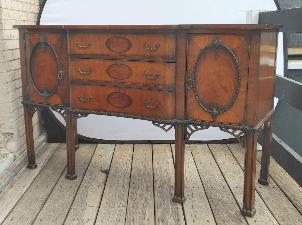 English Sideboard by Frank Drury, Manchester (97): Inlaid mahogany serpentine with 3 drawers and 2 doors, oak secondary wood, fluted straight legs and open fret corners. 60" X 23" X 37"h (From a Rowayton CT Estate)