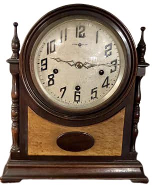 Mantle Clock: Wooden mantel clock. Wear is consistent with age. Minor fading and scratches. Clocks are not guaranteed to work. Measures: 10" x 6.5" x 12" (103-287)